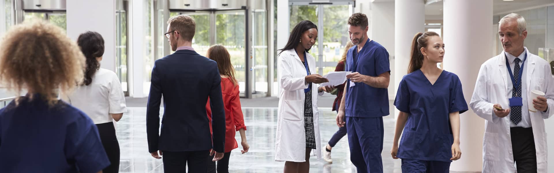 Training instructor answering questions from student as she points to her notes.