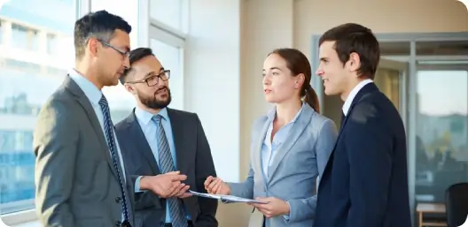 Four people having a safety program meeting with Raising The Standard safety consultants for a construction company jobsite in Hawaii.