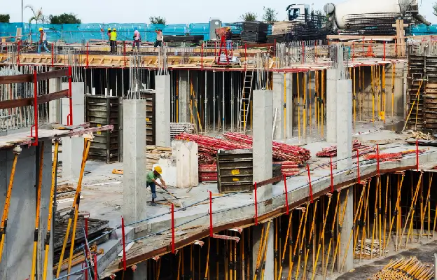 A Honolulu Site Safety and Health Officer (SSHO) in high-visibility gear conducting a worksite safety audit on a clipboard.